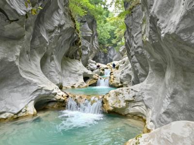 AI-generated illustration of Canyoning With Blažka — canyoners descending a narrow limestone gorge with turquoise pools near Bovec