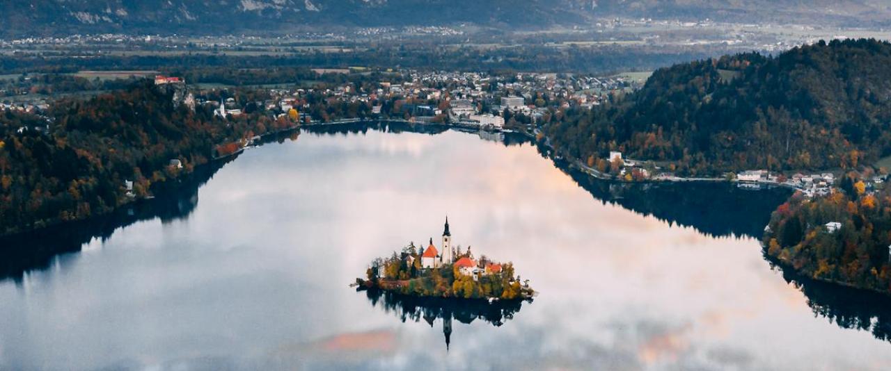 Free A breathtaking aerial view of Slovenia's Lake Bled surrounded by autumn foliage and mountains. Stock Photo