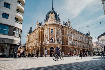 A bustling urban scene in Ljubljana, Slovenia, showcasing stunning architecture and vibrant street life.