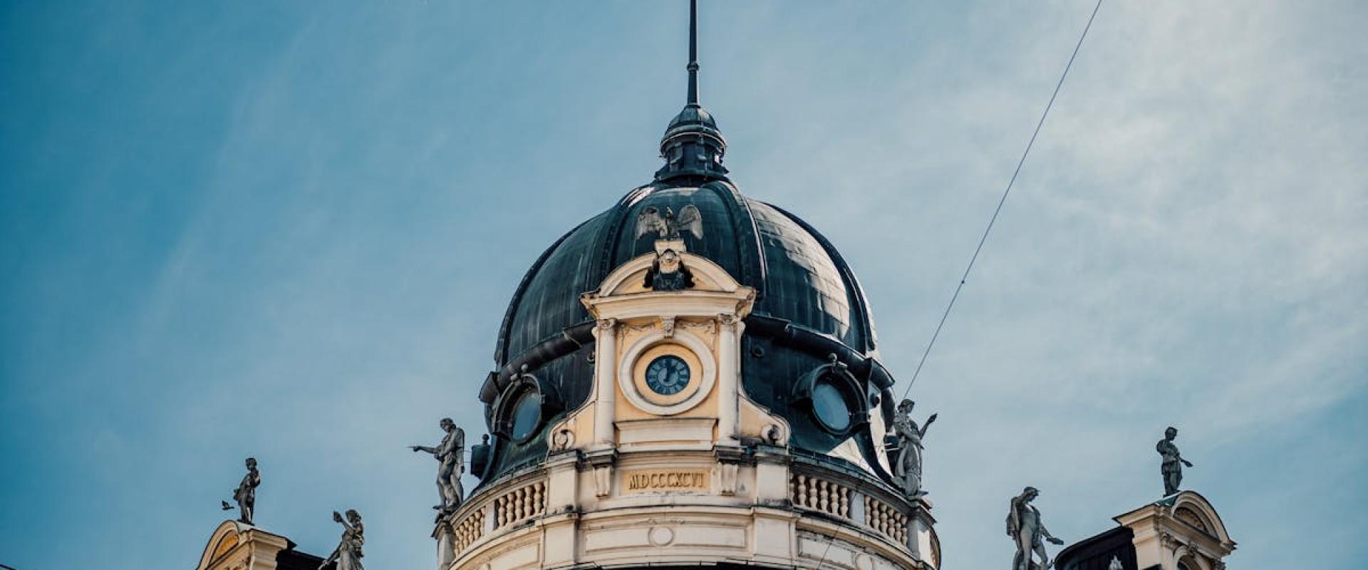 Captivating shot of ornate dome and statues in Ljubljana, Slovenia against a blue sky.