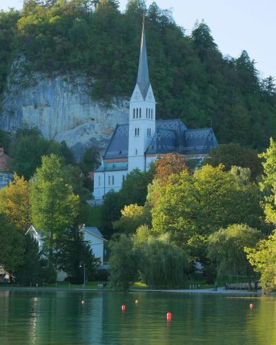 Scenic view of a church by Lake Bled with lush greenery in Slovenia.
