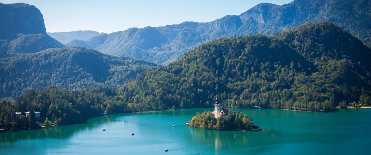 A breathtaking aerial view of Lake Bled surrounded by lush mountains in Slovenia, capturing serene reflections.
