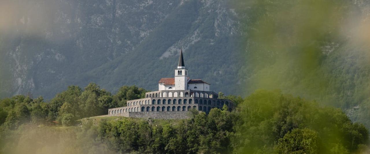 A beautiful church nestled amidst lush greenery and mountains in Kobarid, Slovenia.