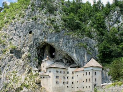 Free Explore the historic Predjama Castle built into the cliffs of Slovenia, surrounded by lush nature. Stock Photo