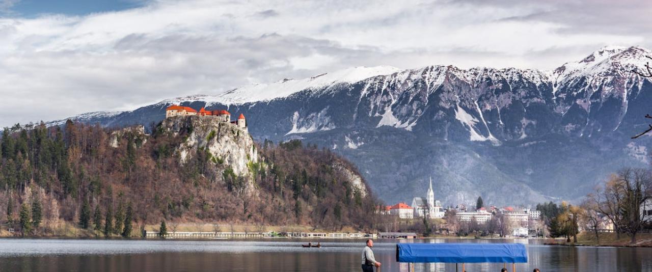 Free A picturesque scene of Lake Bled in Slovenia featuring a traditional Pletna boat and Bled Castle. Stock Photo