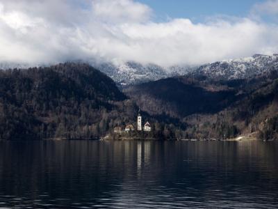 Free Scenic view of Lake Bled with island church surrounded by serene mountains and clouds. Stock Photo