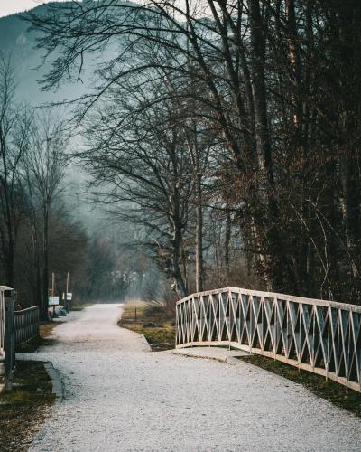 Tranquil winter scene featuring a walkway and bridge in Kamniška Bistrica, Slovenia, inviting peaceful exploration.