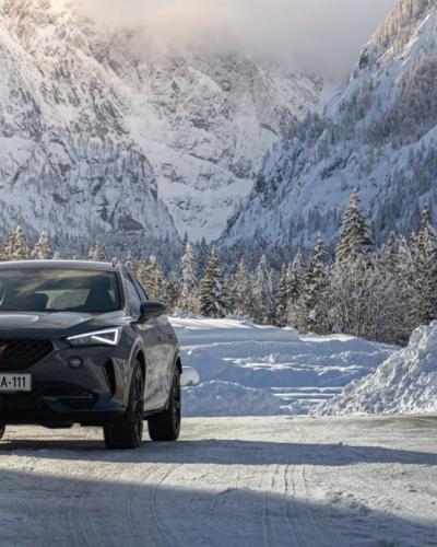 Cupra Formentor driving through snow-covered mountain road in Jesenice, Slovenia.