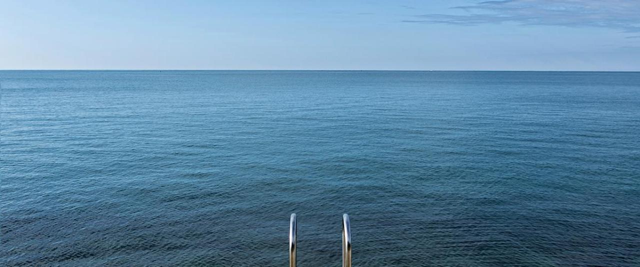 Tranquil scene of the Adriatic Sea from a pier in Piran, Slovenia, offering serene views and peaceful vibes.