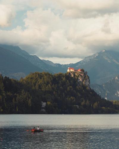Picturesque Bled Castle overlooking serene Lake Bled, framed by majestic mountains.