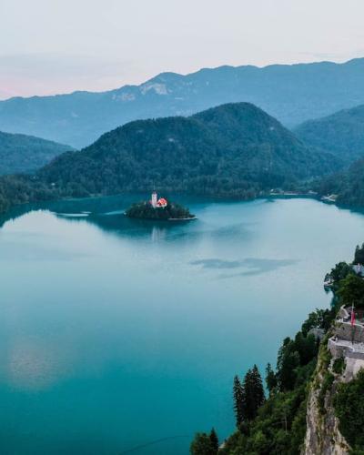 Free Breathtaking aerial view of Bled Castle overlooking Lake Bled in Slovenia surrounded by mountains. Stock Photo