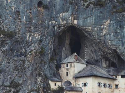 Vertical shot of the iconic Predjama Castle built into a cave in Slovenia.