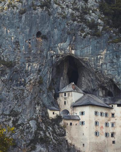 Vertical shot of the iconic Predjama Castle built into a cave in Slovenia.