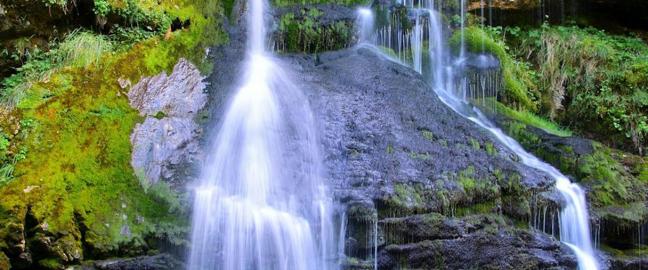Elegant cascade of Virje Waterfall, surrounded by lush greenery in Tolmin, Slovenia. Perfect for nature lovers.