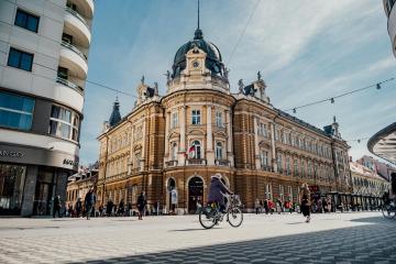 A bustling urban scene in Ljubljana, Slovenia, showcasing stunning architecture and vibrant street life.