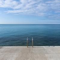 Tranquil scene of the Adriatic Sea from a pier in Piran, Slovenia, offering serene views and peaceful vibes.
