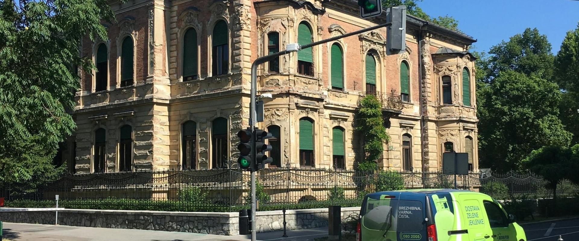 Explore a vintage mansion on a sunny street corner in Ljubljana, Slovenia.