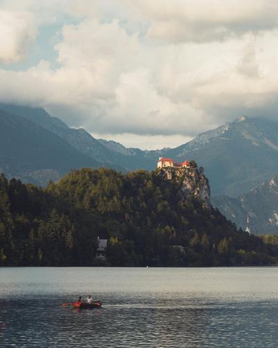 Picturesque Bled Castle overlooking serene Lake Bled, framed by majestic mountains.