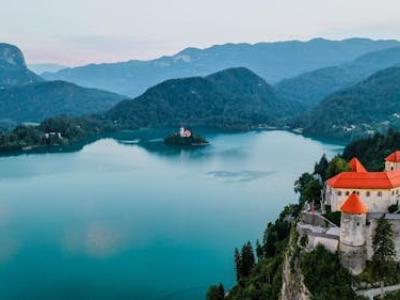 Free Breathtaking aerial view of Bled Castle overlooking Lake Bled in Slovenia surrounded by mountains. Stock Photo