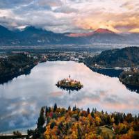 Free A breathtaking aerial view of Slovenia's Lake Bled surrounded by autumn foliage and mountains. Stock Photo