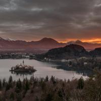 Sunrise glowing orange over Lake Bled, its island church and the surrounding mountains, Slovenia