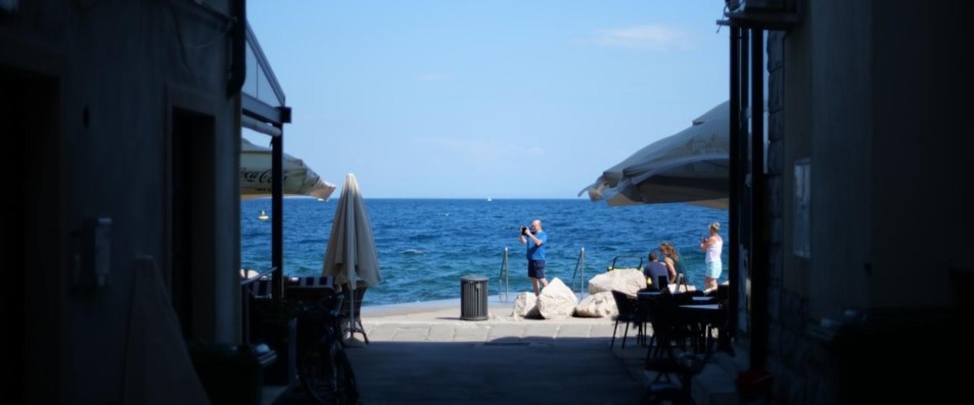 a group of people sitting at tables by the water
