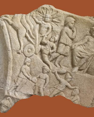 A photograph of a fragmented stone relief sculpture depicting mythological figures, including a sun god with radiating rays, a seated figure, and other human forms, set against a solid terracotta background.