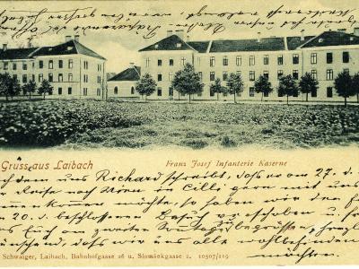 A vintage postcard showing a large, multi-winged institutional building complex with a grassy field in the foreground, featuring printed text "Grüsse aus Laibach" and "Franz Josef Infanterie Kaserne".