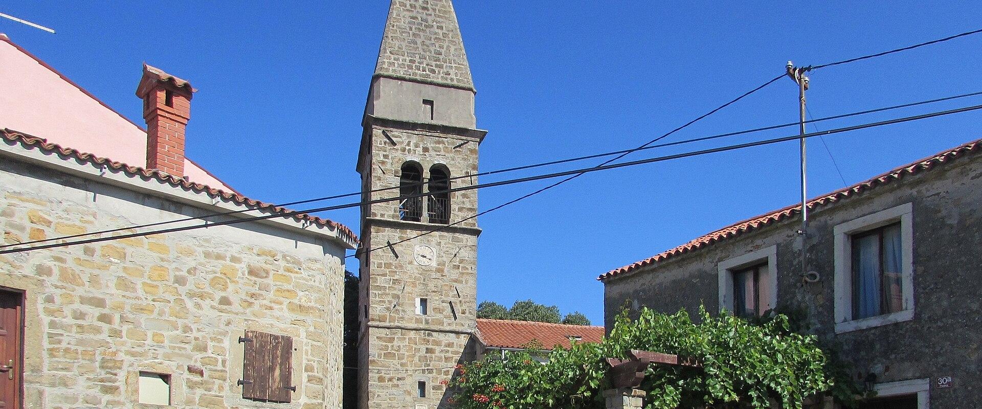 Bell tower of the Church of St. Blaise rising above the stone houses of Padna