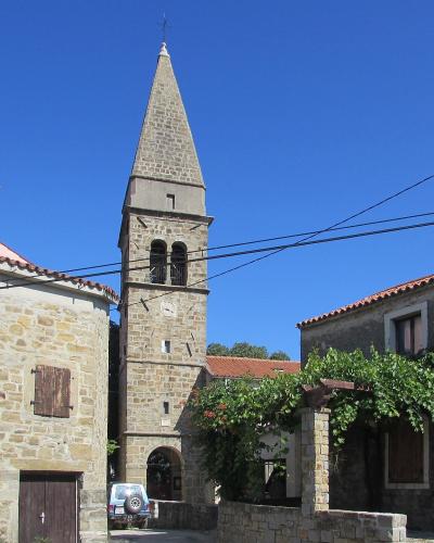 Bell tower of the Church of St. Blaise rising above the stone houses of Padna