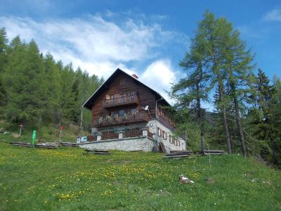 The mountain lodge on Peca among larch meadows