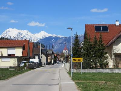 A residential street in Mengeš with the snow-capped Kamnik Alps behind