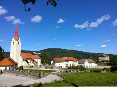 The village of Adlešiči with its white parish church in Bela Krajina