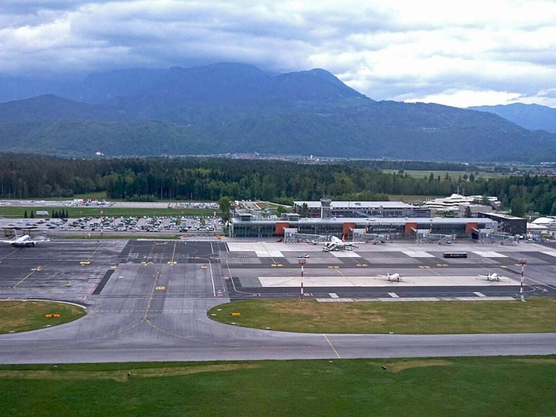 Aerial view of Ljubljana Jože Pučnik Airport terminal and apron with mountains behind