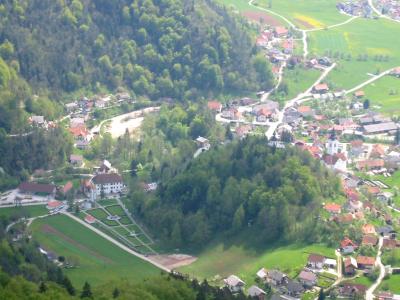 Polhov Gradec seen from the hills above, its houses spread along a green valley in the Polhov Gradec Hills west of Ljubljana.